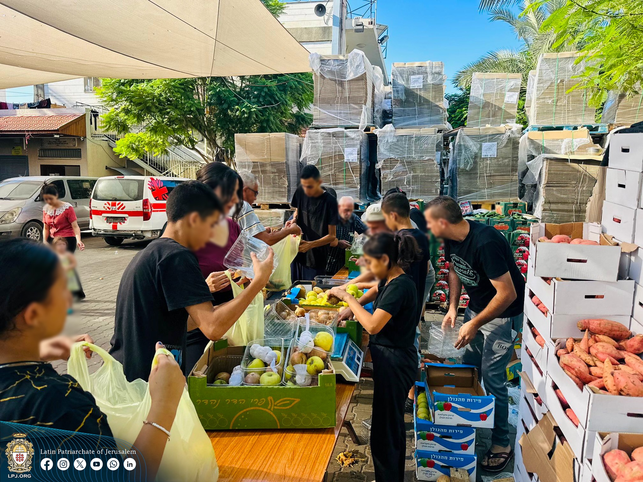 متطوعون يعملون على تجهيز الطرود الغذائيّة (تصوير: إعلام البطريركيّة اللاتينية)