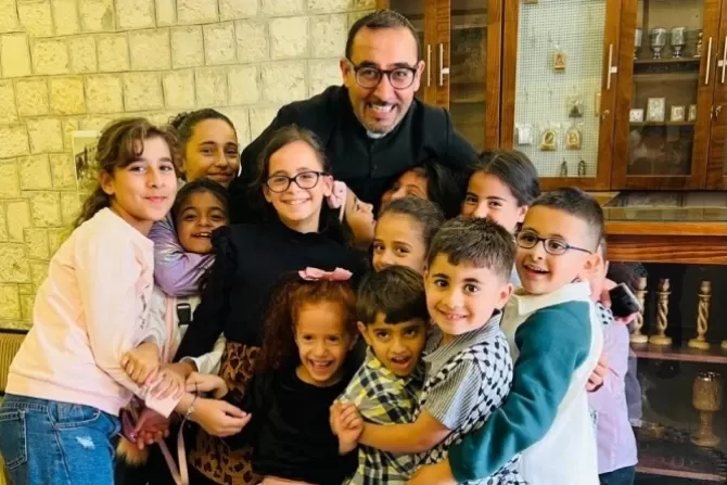 Father Bashar Fawadleh, Latin rite pastor of Taybeh, with children from his community.